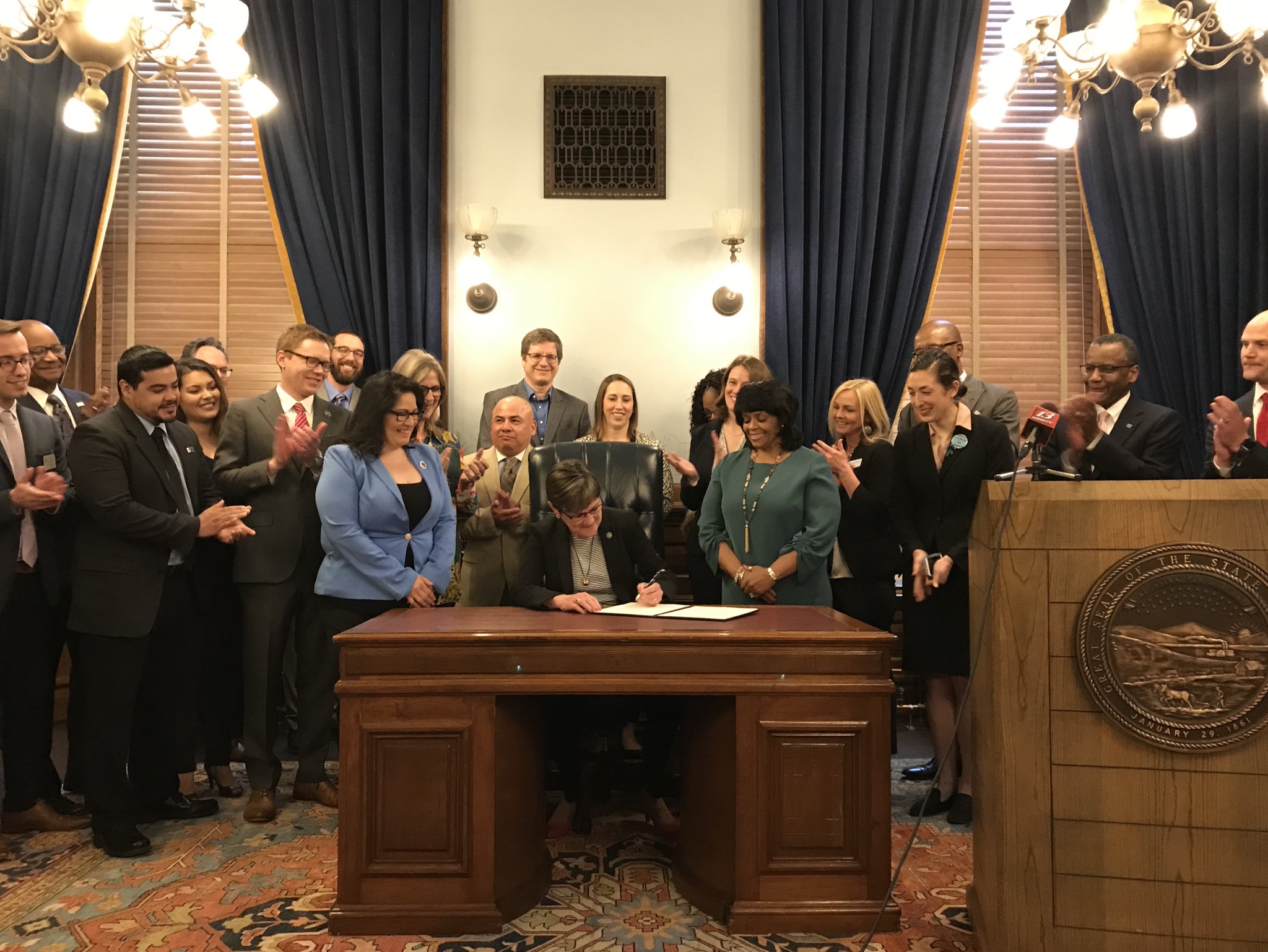 Governor Kelly signs executive order at desk